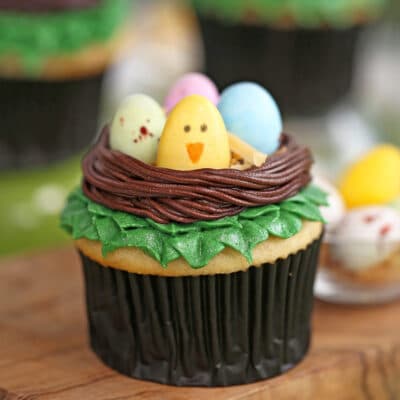 Close-up of Easter Bird's Nest Cupcakes on a wooden cutting board.