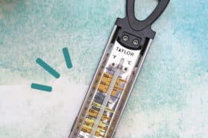 Overhead shot of a thermometer on a blue-green background, with text overlay for Pinterest.