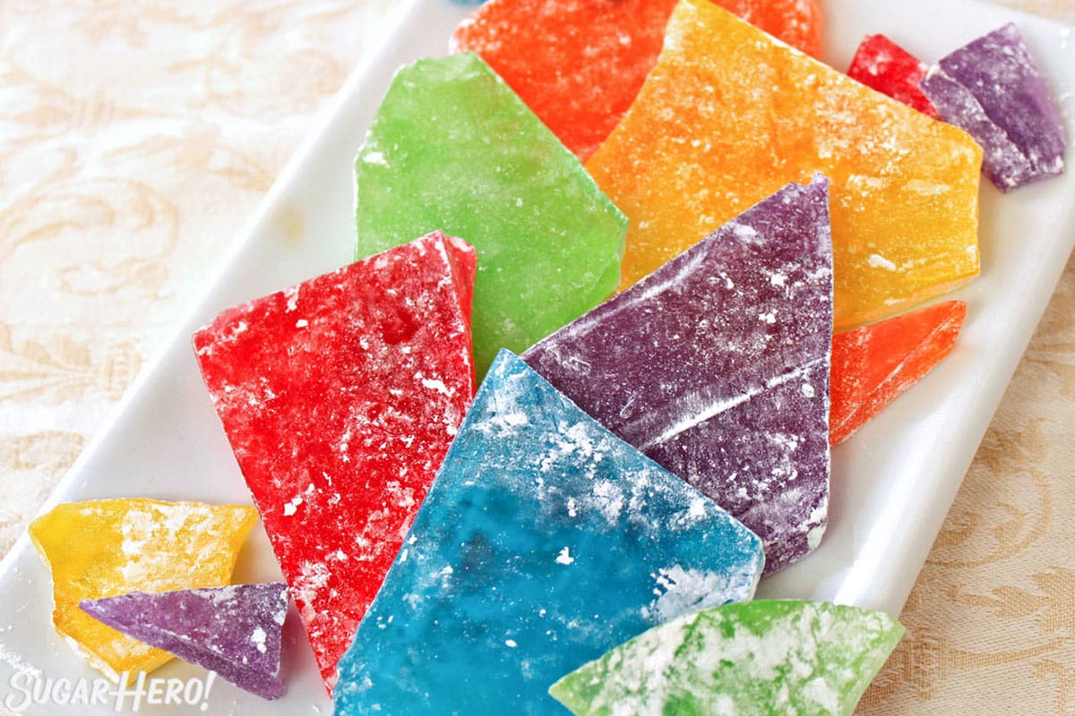 Colorful hard candy dusted with powdered sugar on a white platter.