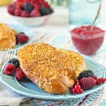 Mascarpone Rhubarb Stuffed French Toast on a blue plate with fresh berries around.