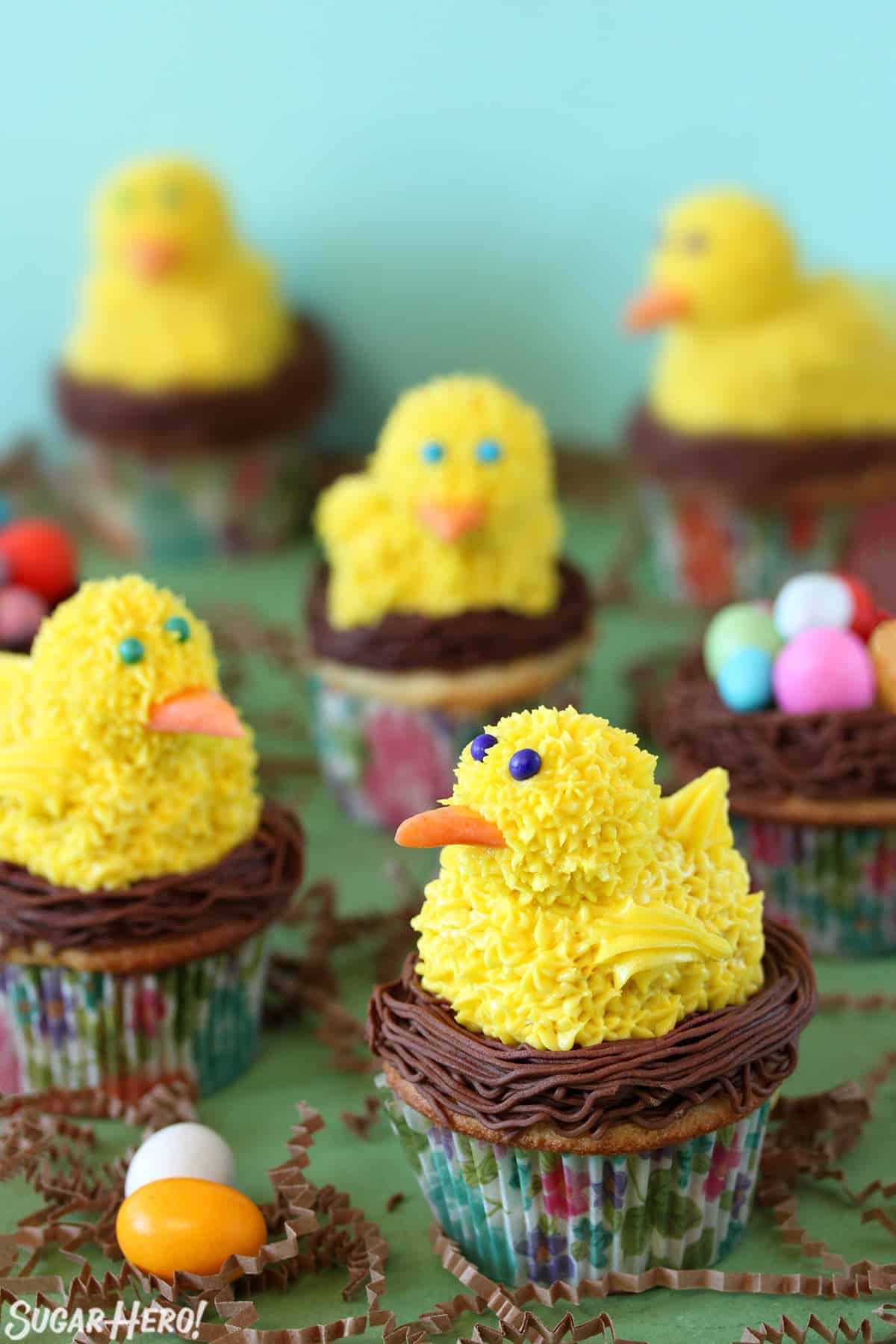 5 Spring Chick Cupcakes on a green surface.