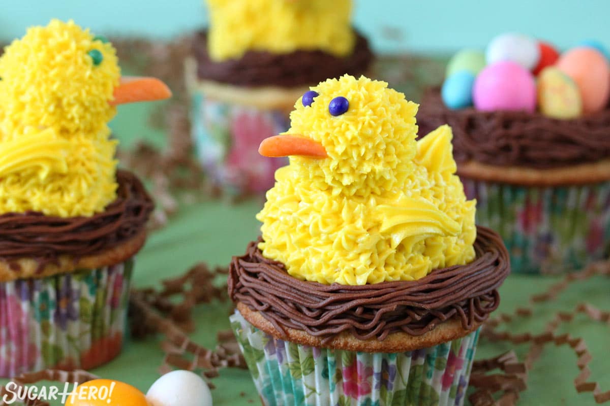 Close up of a Spring Chick Cupcake with more cupcakes in the background.