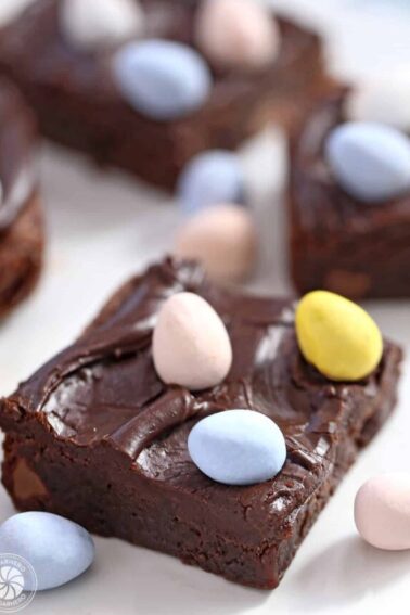 Easter Egg Brownies on a white plate with colorful Cadbury mini chocolate eggs on top.