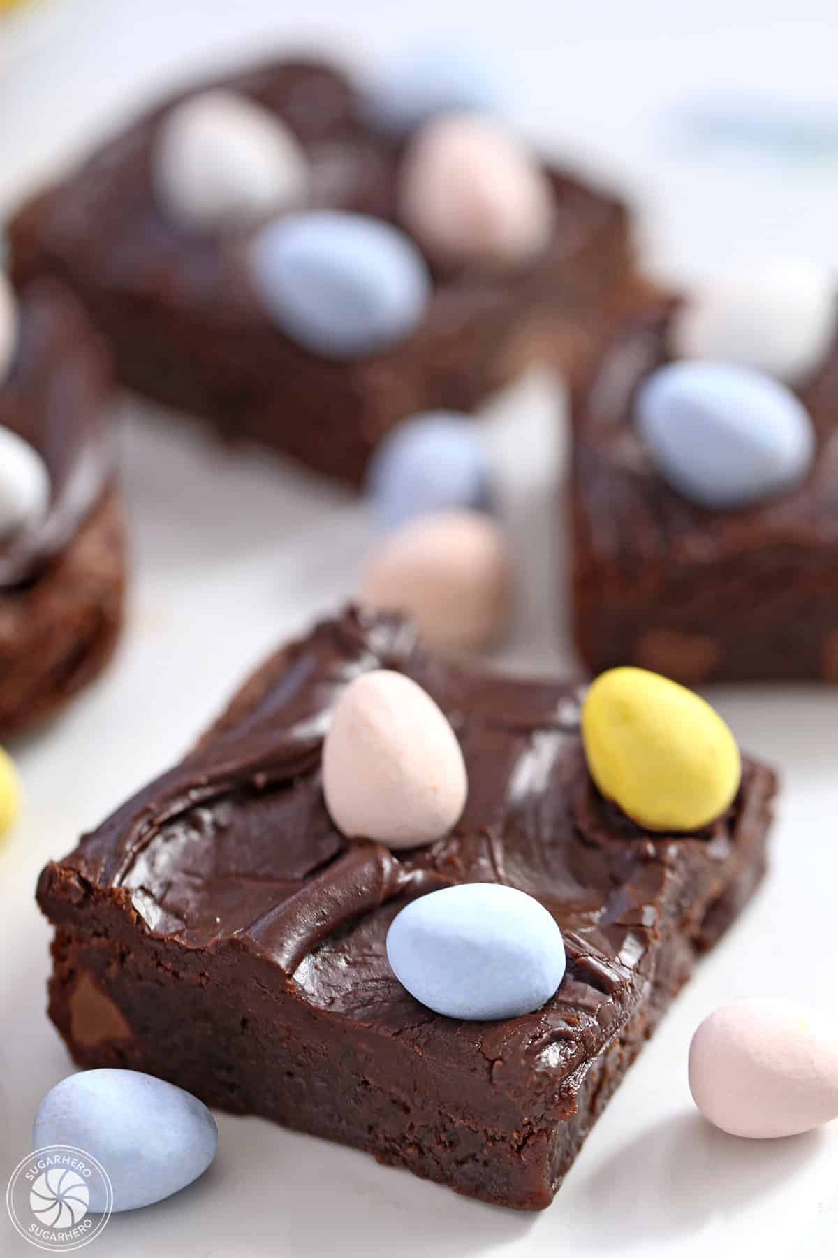 Easter Egg Brownies on a white plate with colorful Cadbury mini chocolate eggs on top.