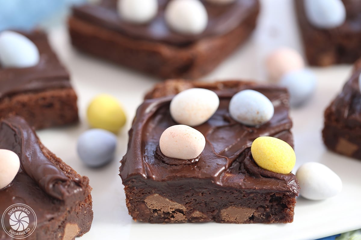 Easter Egg Brownies on a white plate with colorful Cadbury mini chocolate eggs on top.