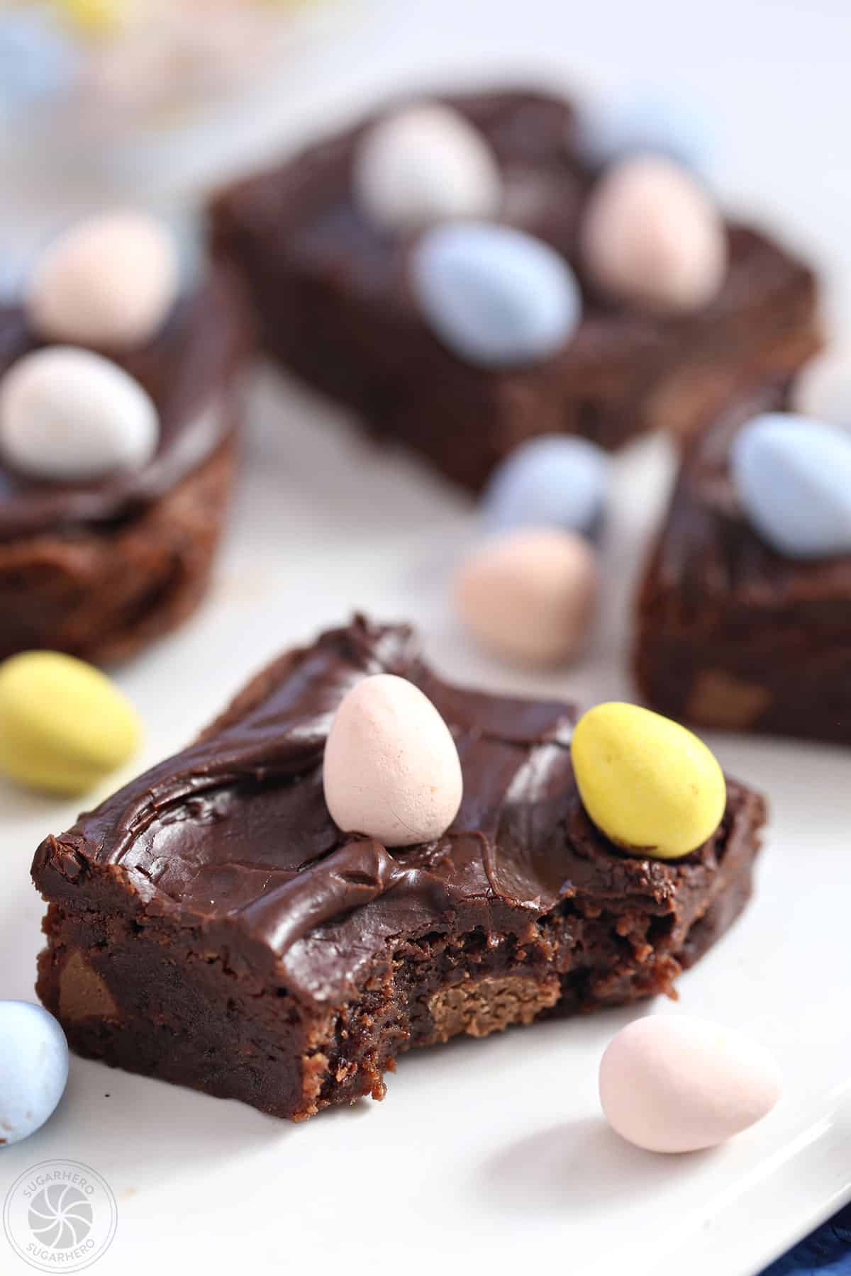 Easter Egg Brownie on a white platter with a bite taken out of it.