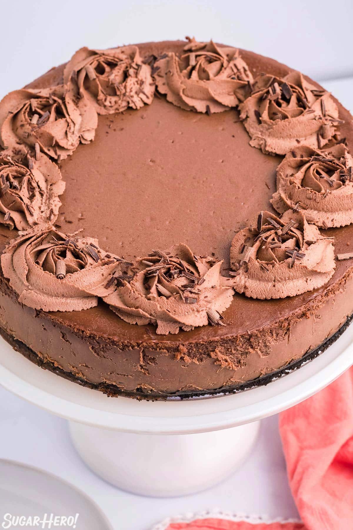 Close up of the top of a Chocolate Cheesecake on a white cake platter.