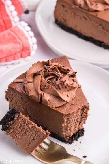 A slice of Chocolate Cheesecake with a bite on a fork to show texture.