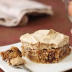 A Meringue-Topped Blondie slice on a white plate with a fork holding a bite.