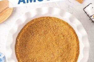 Overhead shot of white fluted pie pan with graham cracker crust, with text on top for Pinterest.