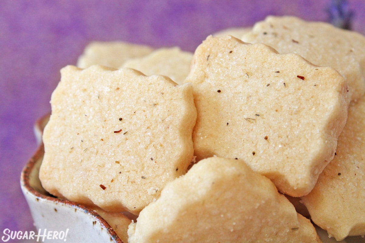 Close-up of square lavender shortbread cookies with lavender sugar sprinkled on top.