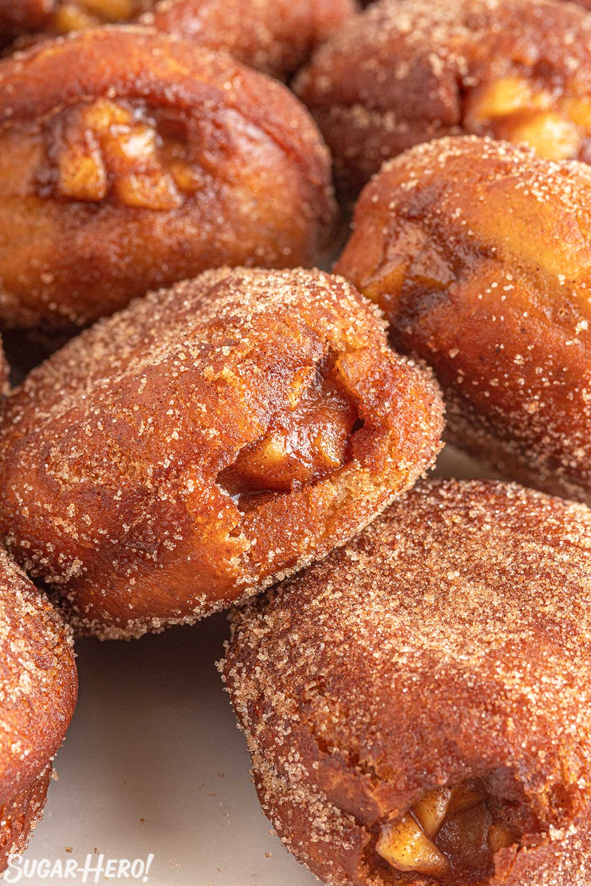 Close-up of a group of Apple Donuts rolled in cinnamon sugar.