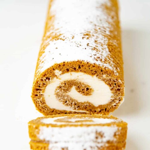 Pumpkin Swiss Roll Cake with several slices cut from the front.
