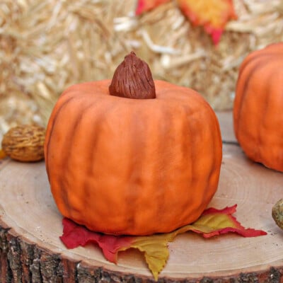 Close up of a mini Pumpkin Bundt Cake on a piece of wood with other fall decor.