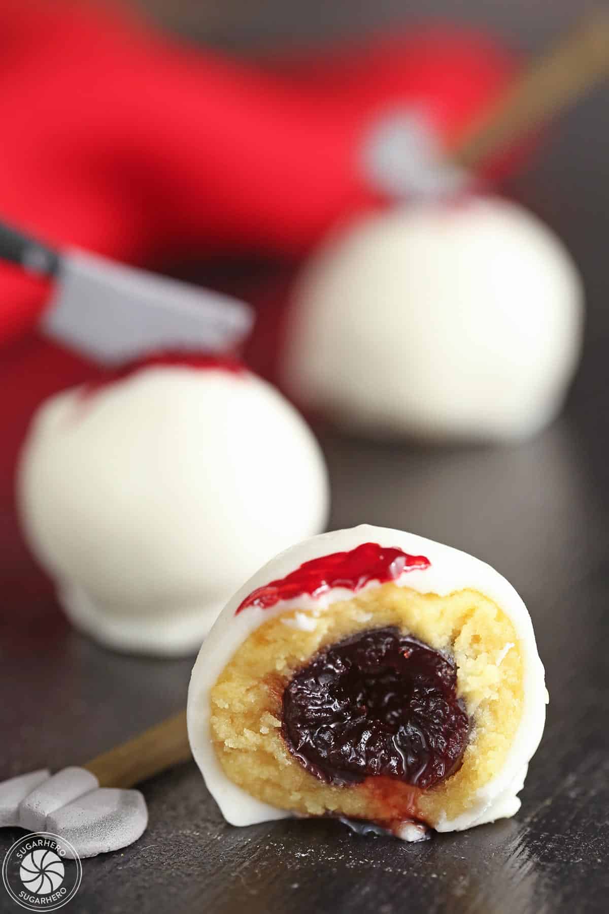 Close-up of a Bloody Halloween Cake Ball, cut in half to show the cherry inside.