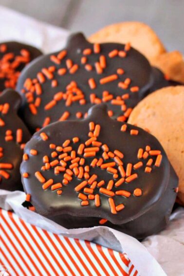 Assortment of Pumpkin Marshmallows, some dipped in chocolate, in an orange-striped gift box.