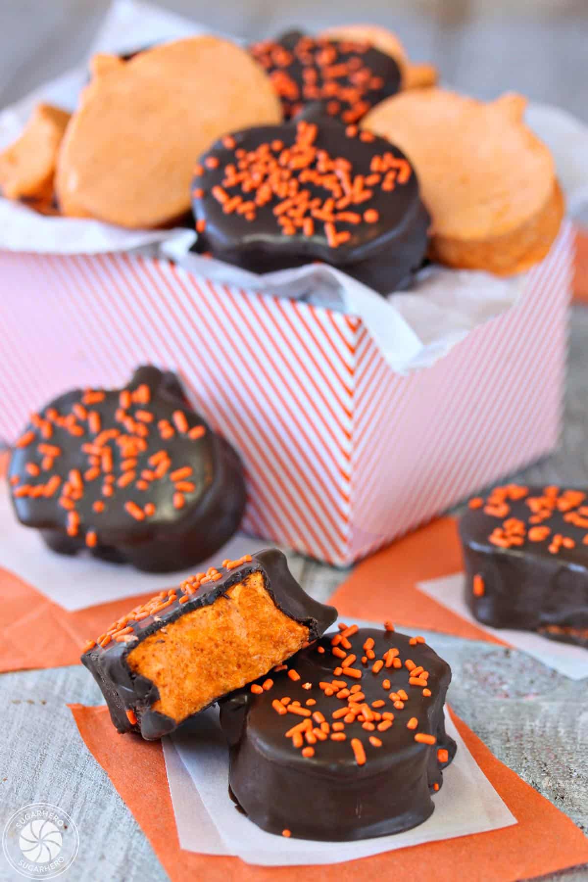 Chocolate-Dipped Pumpkin Marshmallows displayed on parchment paper and in an orange-striped gift box.