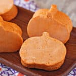 Pumpkin Marshmallows cut into the shape of pumpkins, on a wooden platter.