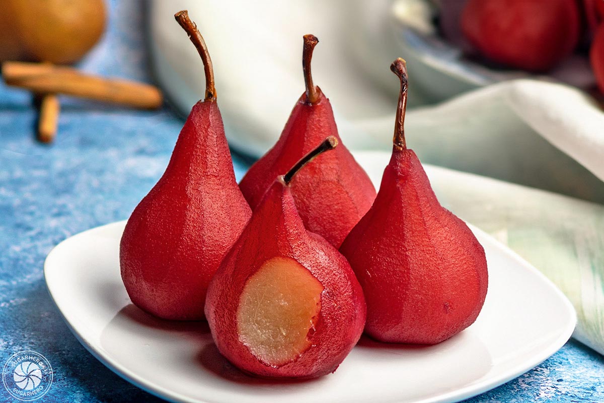 Close up of Red Wine Poached Pears with a bite removed from the front pear.