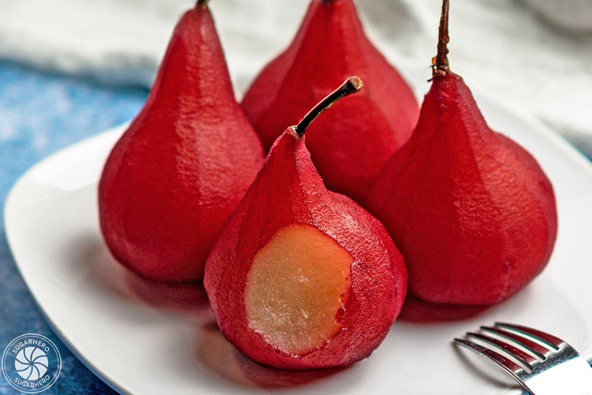 Close up of 4 Red Wine Poached Pears with a bite removed from front pear.