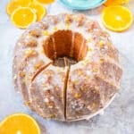 Orange Bundt Cake on a cooling rack, with a large slice cut into it.