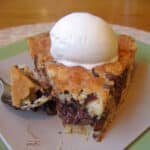 A slice of Chocolate Chip Cookie Pie (Tollhouse Pie) with a bite removed.