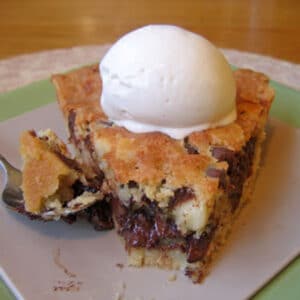 A slice of Chocolate Chip Cookie Pie (Tollhouse Pie) with a bite removed.