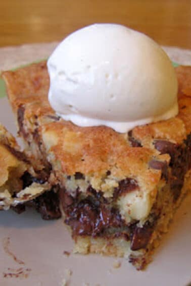 A slice of Chocolate Chip Cookie Pie (Tollhouse Pie) with a bite removed.