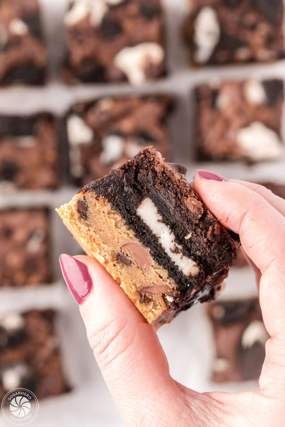 Hand with pink nails holding up an Oreo Brookie cookie bar.