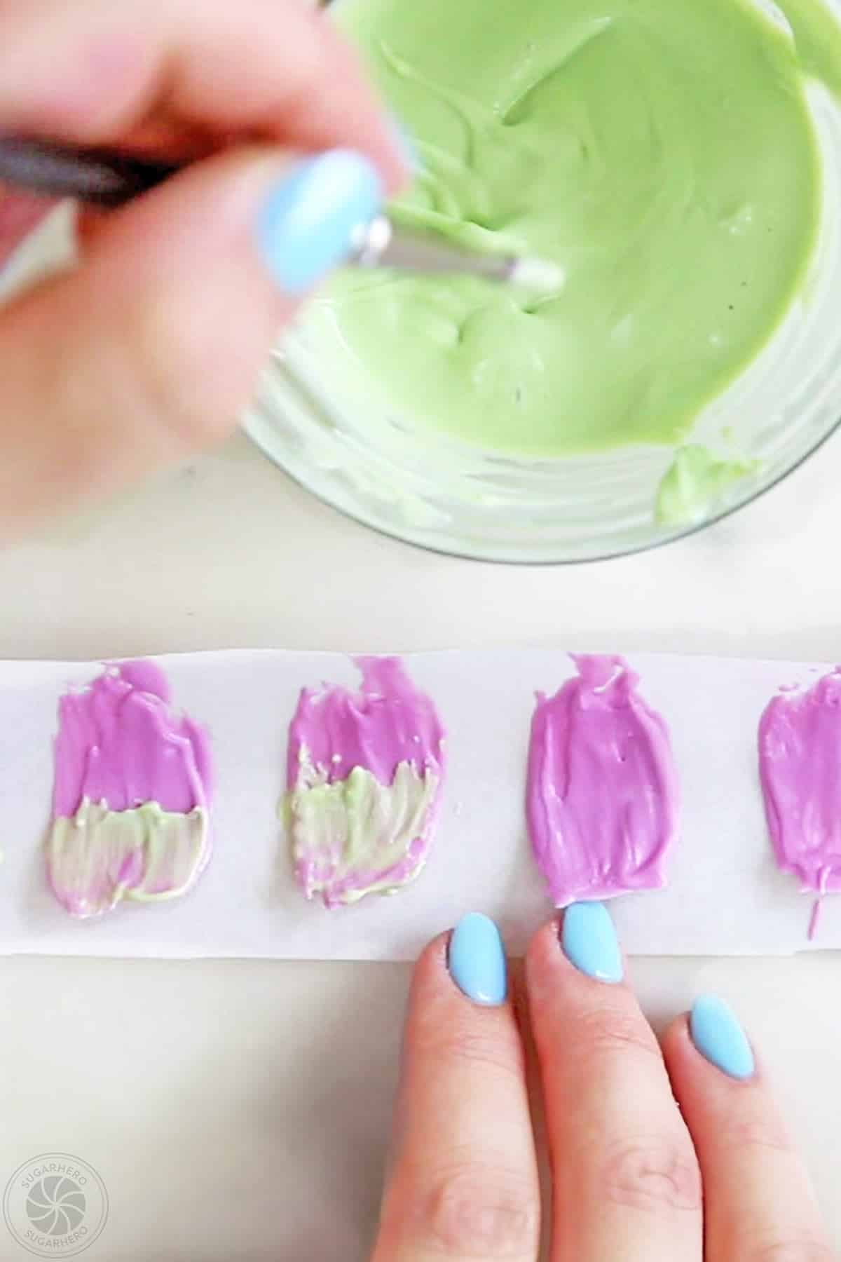 Brushing green candy melt accents on purple candy melt petals.