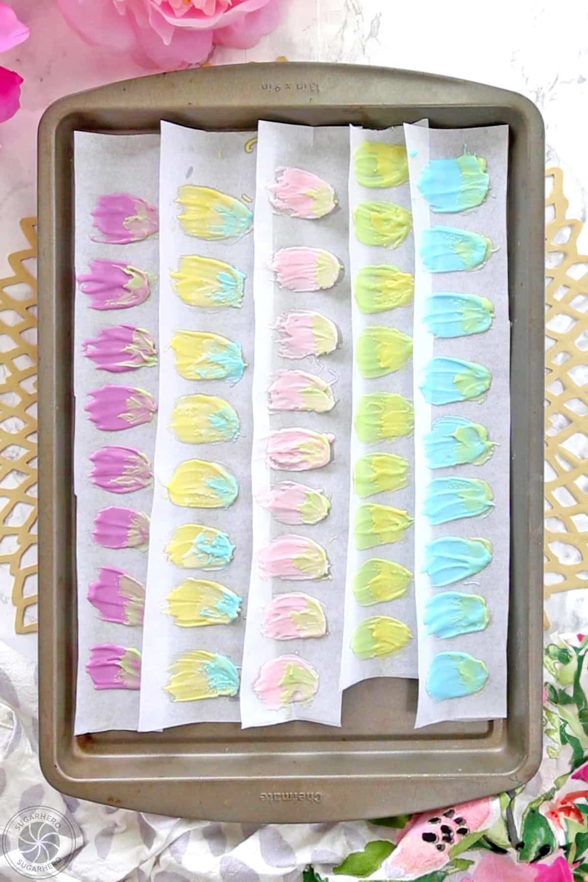 A baking sheet filled with multicolored candy melt petals.