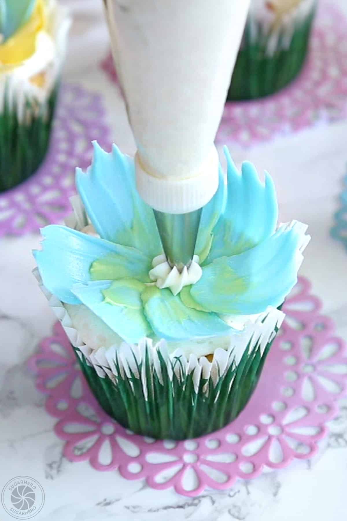 Piping a dab of white buttercream in the middle of a chocolate flower.