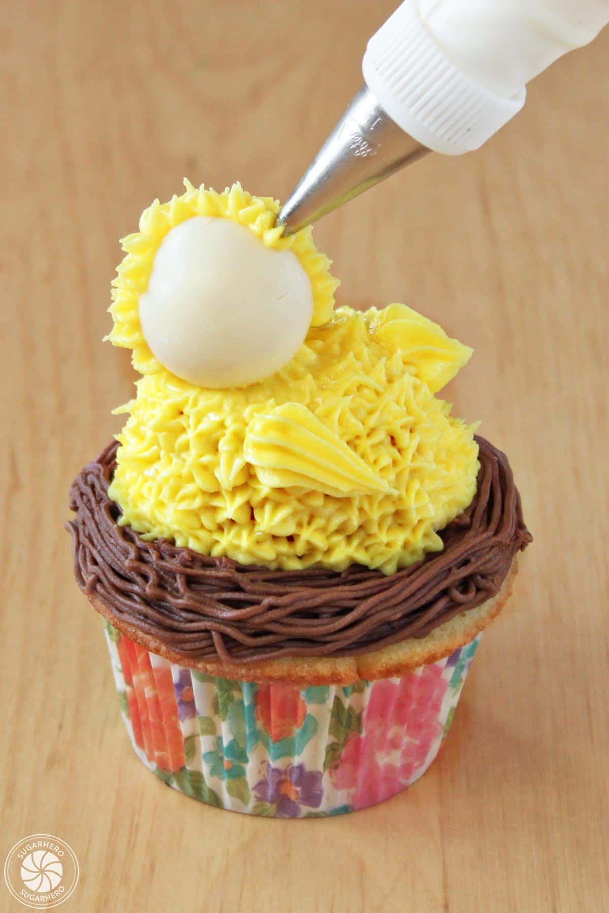 Covering a chick's head with yellow buttercream.