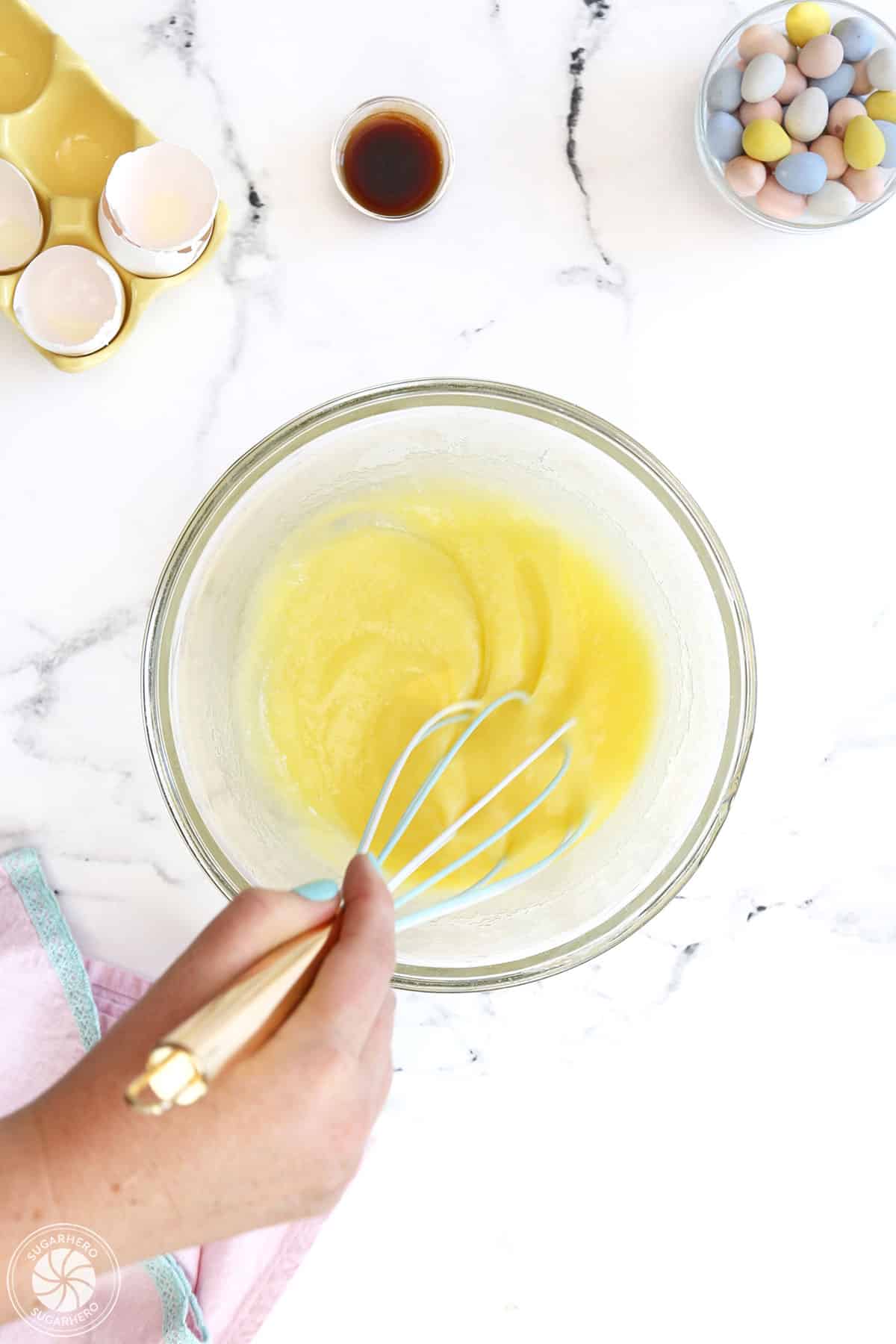 Whisking eggs and granulated sugar together.