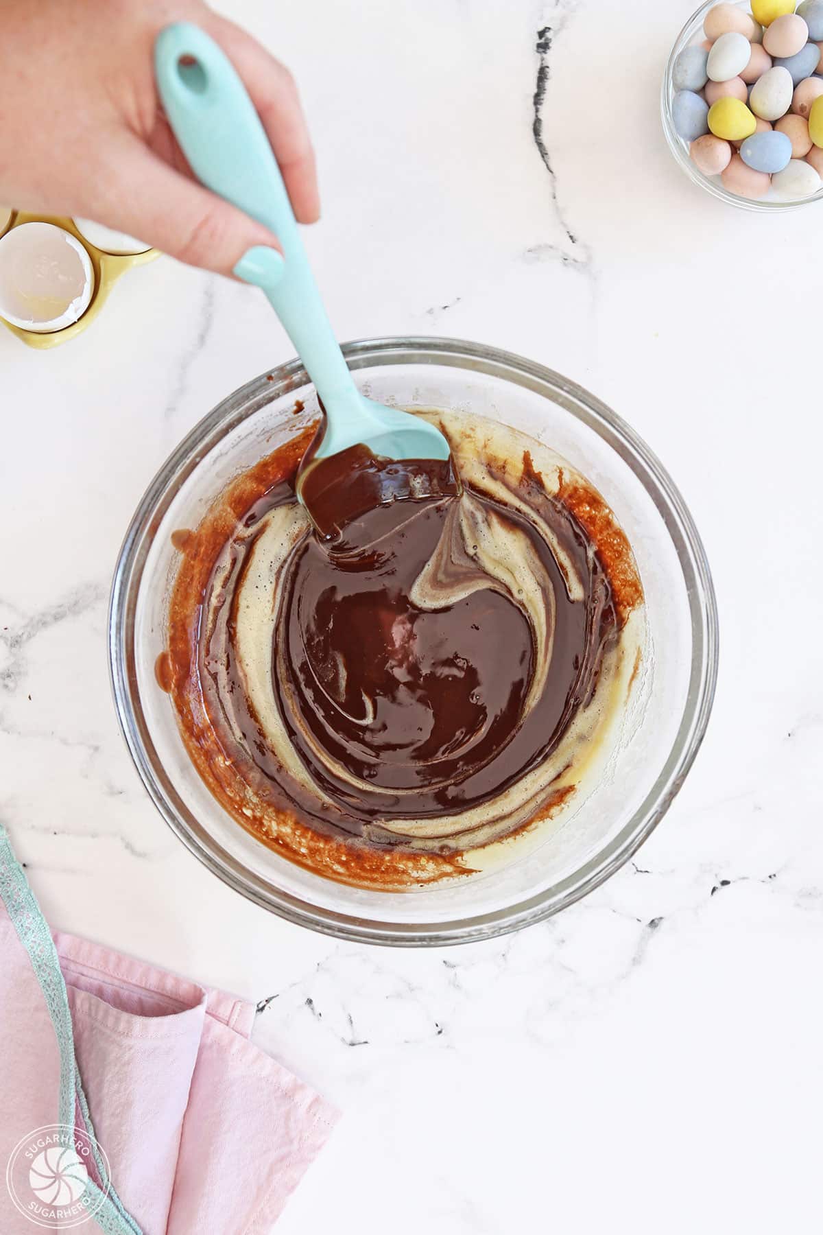 Stirring eggs and melted chocolate together.