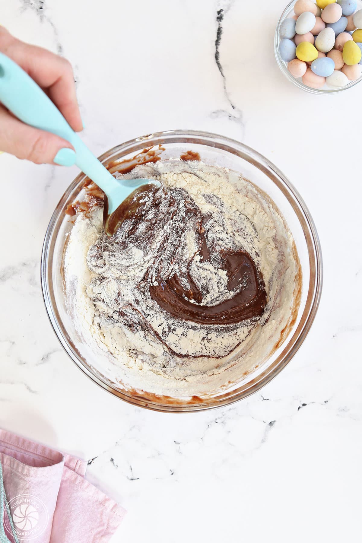 Stirring flour and other dry ingredients into brownie batter.