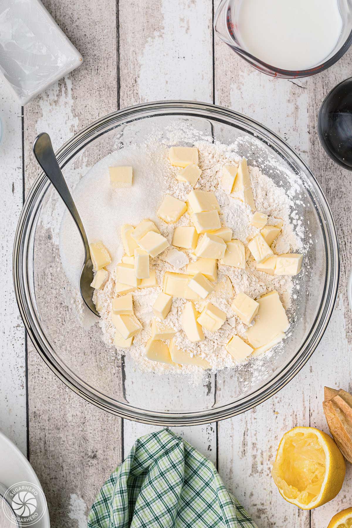 A mixing bowl with dry ingredients and chunks of butter.