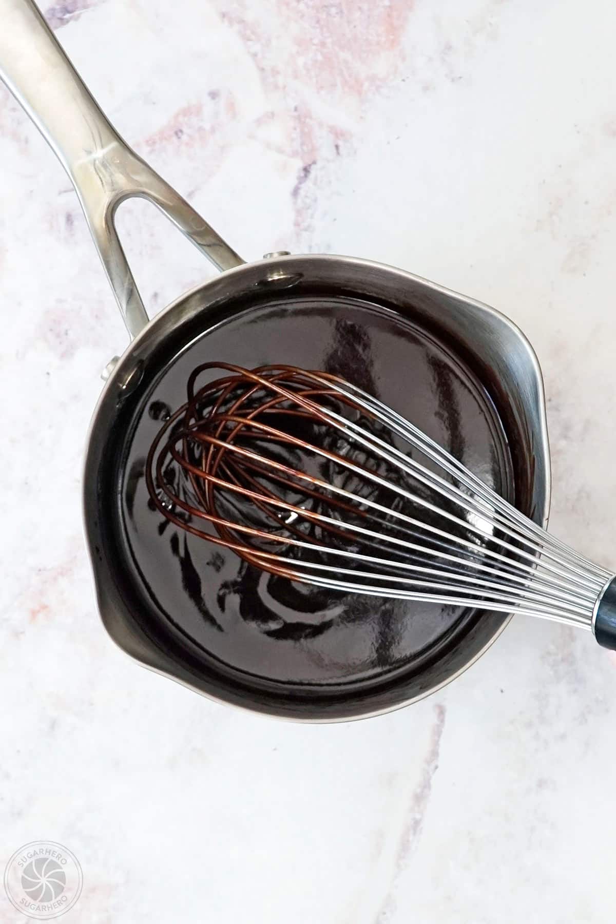 Smooth chocolate spread mixture in a saucepan with a whisk.