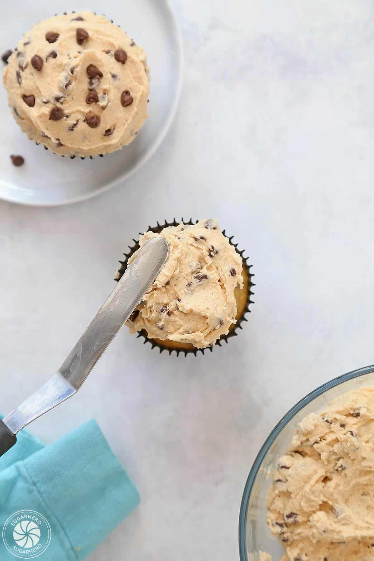 Offset spatula spreading froting on a cupcake.