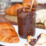 A jar of Coconut Chocolate Spread with a spoon in it.