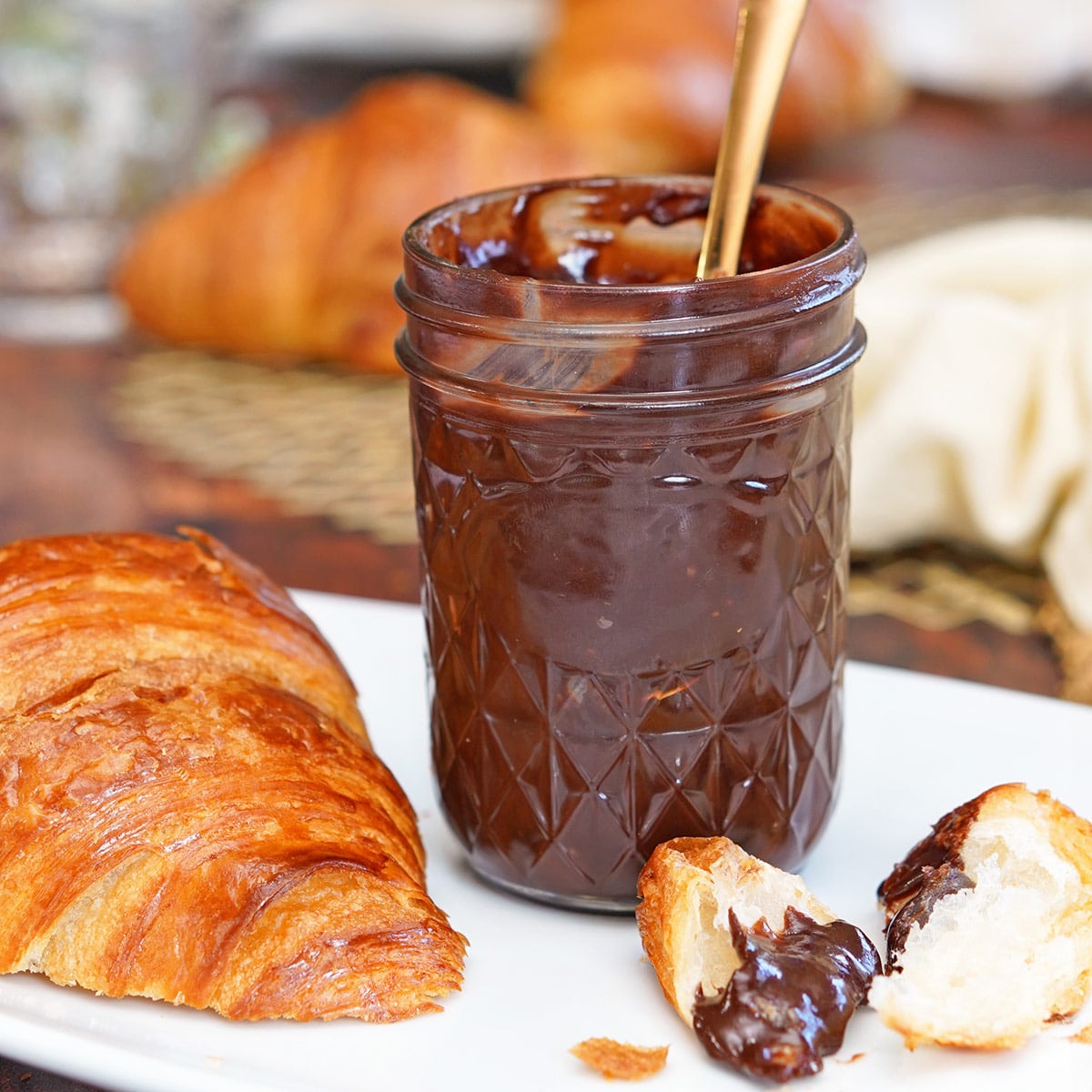 A jar of Coconut Chocolate Spread with a spoon in it.