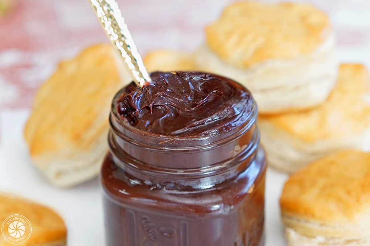 Close up of a small jar of Sugar-Free Chocolate Spread surrounded by biscuits.