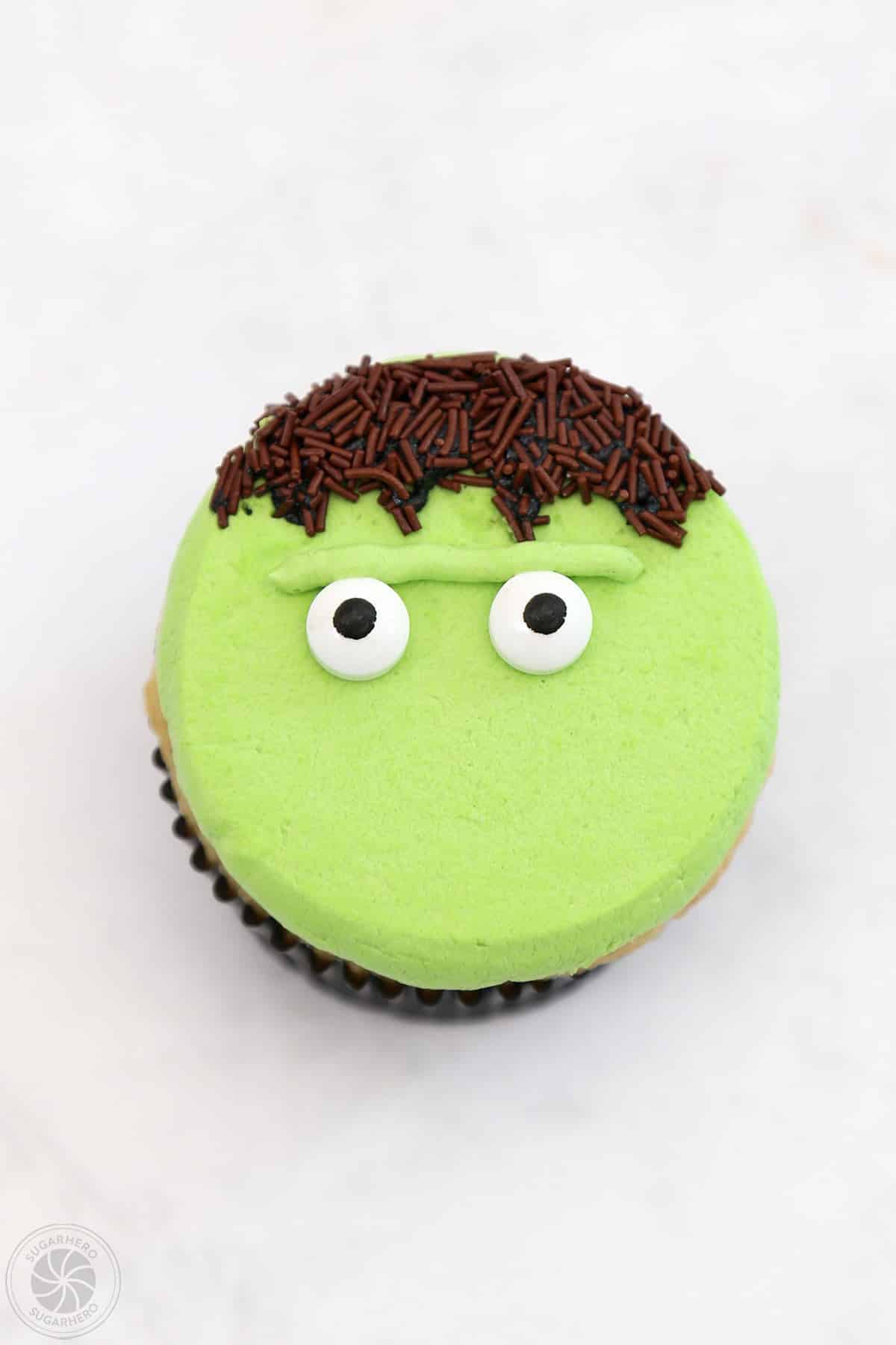 A Frankenstein Cupcake with a piped unibrow and two candy eyes.