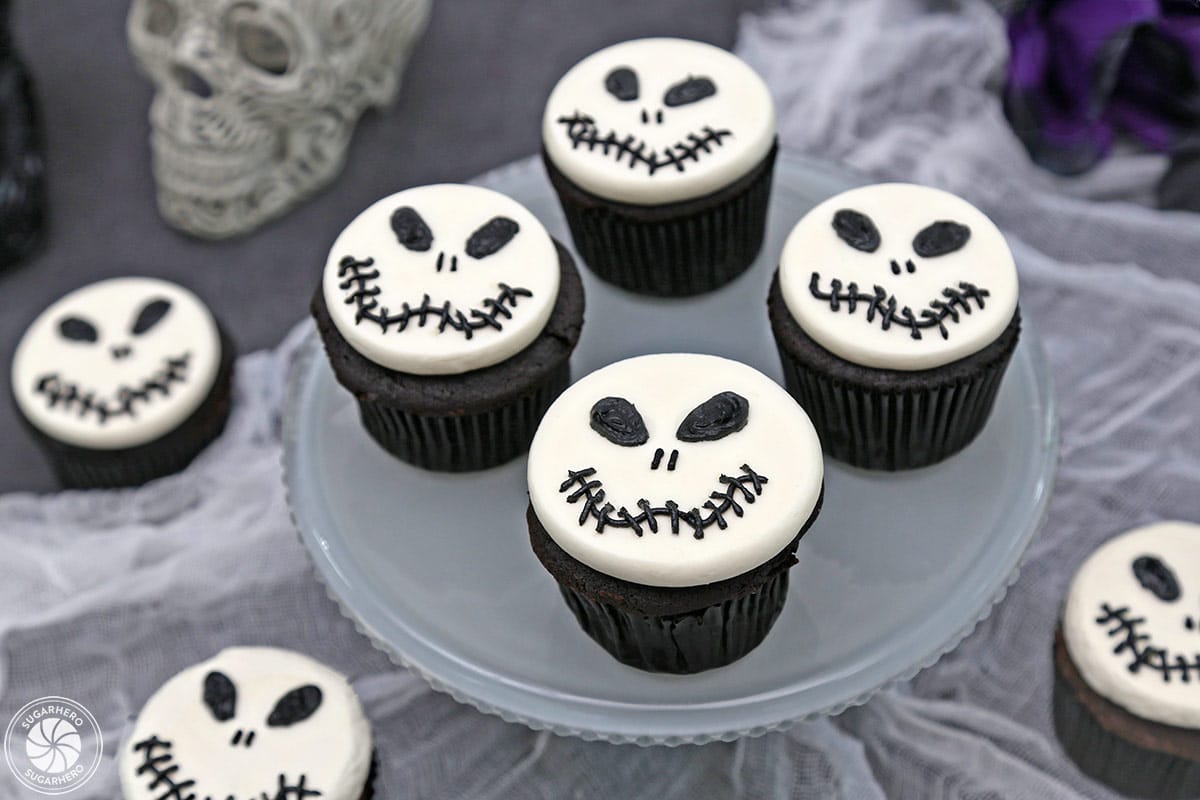 Four Skull Cupcakes on a frosted glass cake plate.