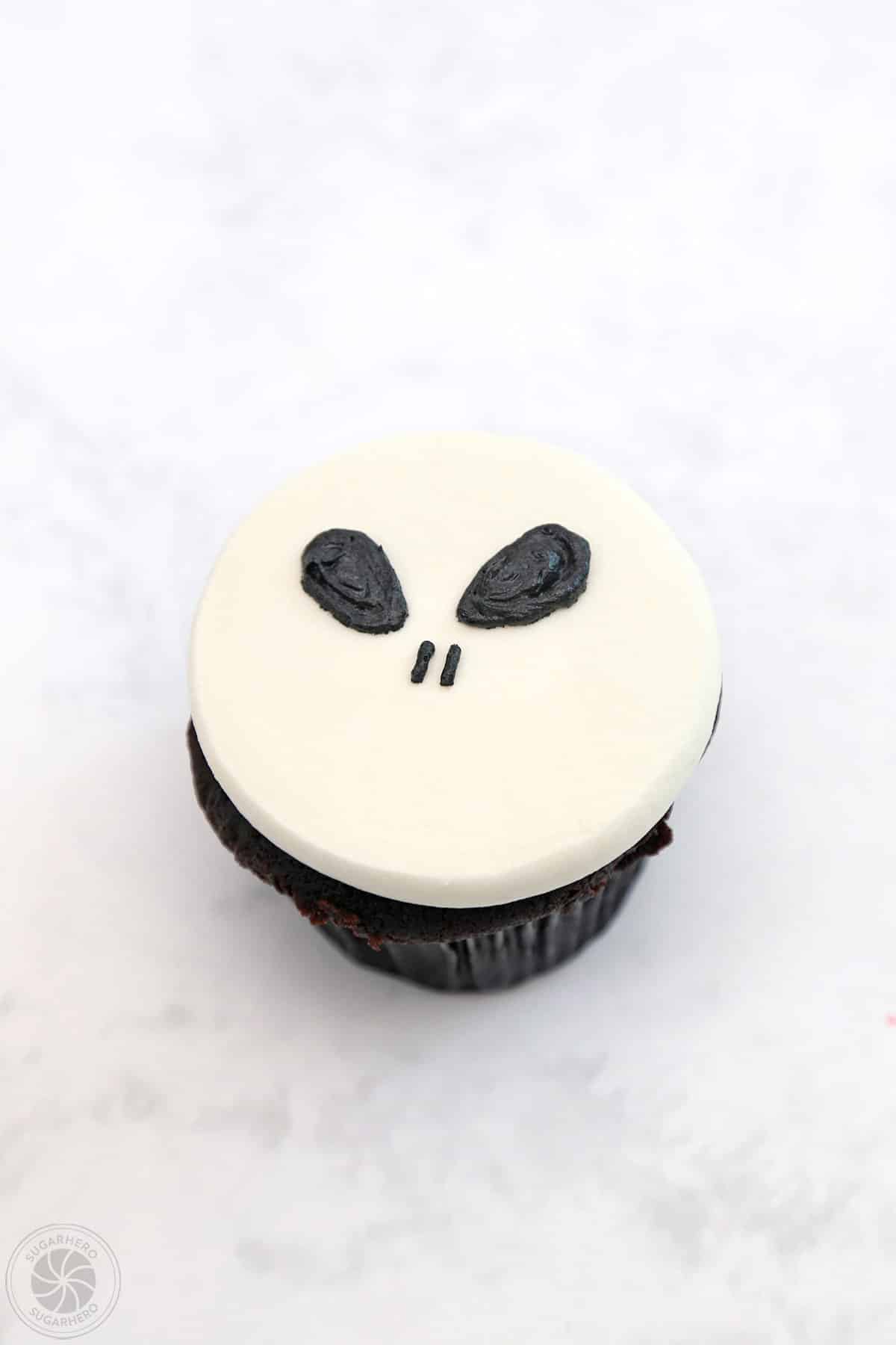 A cupcake with two black eyes and two black nose slits.