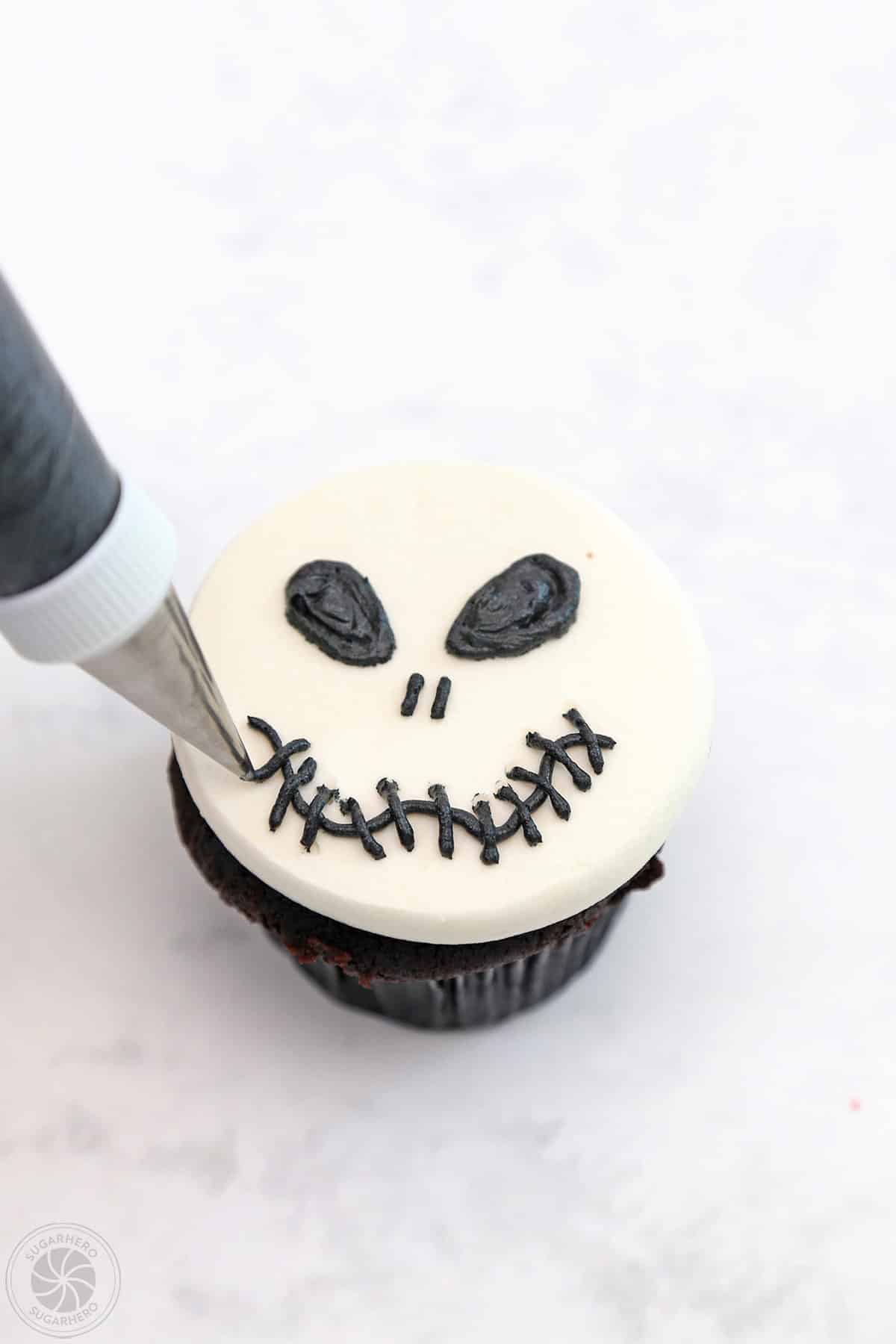 Piping scar lines across the mouth of a Skull Cupcake.