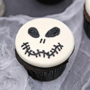Close up of a Skull Cupcake on white material.
