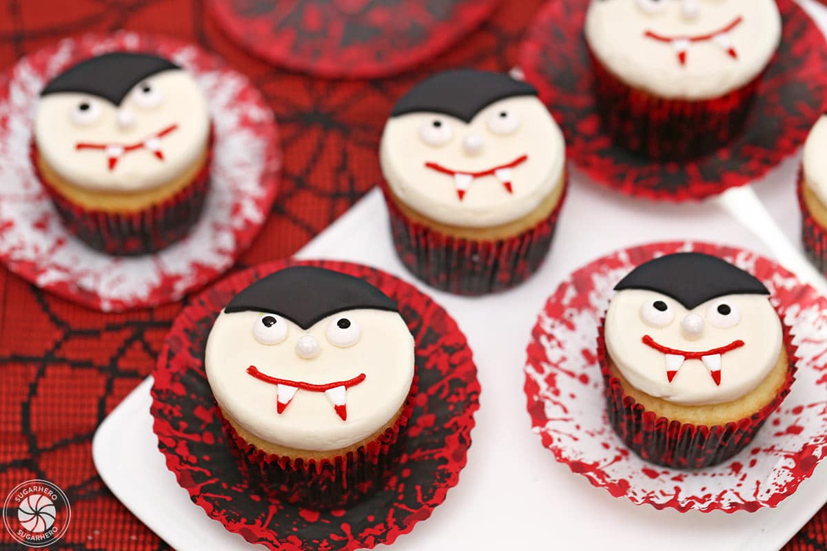 Several Vampire Cupcakes on a white tray with red, white and black wrappers.