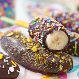 Close up of two chocolate bananas stacked on one another with the top one cut to show the center.