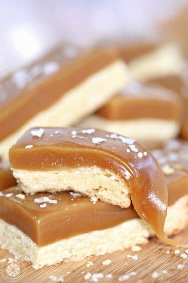 Close up of 2 stacked salted caramel bars with the caramel pulled on the top bar.